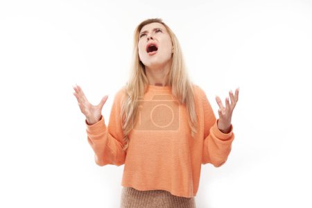Foto de Retrato enojado rubia joven gritando aislado en el fondo del estudio blanco, mostrando emociones negativas - Imagen libre de derechos