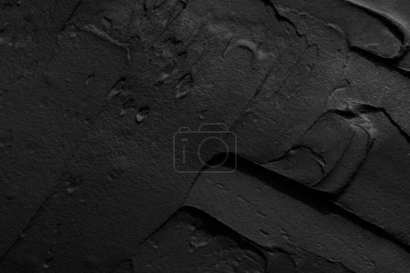 Photo for Decorative black putty background. Wall texture with filler paste applied with spatula, chaotic dashes and strokes over plaster. Creative design, stone pattern, cement - Royalty Free Image