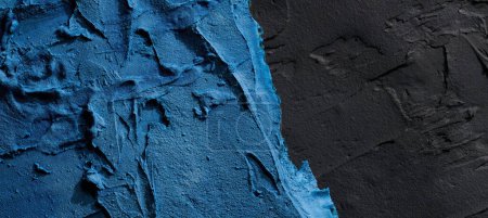 Foto de Fondo decorativo de masilla negra azul. Textura de pared con pasta de relleno aplicada con espátula, guiones caóticos y trazos sobre yeso. Diseño creativo, patrón de piedra, cemen - Imagen libre de derechos