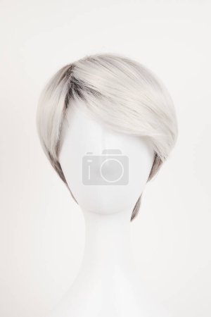 Téléchargez les photos : Perruque blonde argentée naturelle sur tête de mannequin blanche. Cheveux courts sur le porte perruque en plastique isolé sur fond blanc, vue de face - en image libre de droit