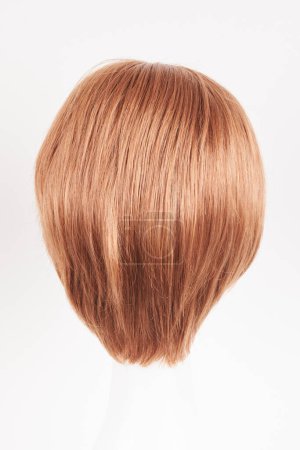 Photo for Natural looking ginger wig on white mannequin head. Short hair on the plastic wig holder isolated on white background, back vie - Royalty Free Image