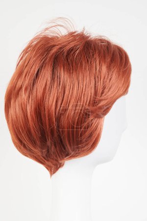 Photo for Natural looking ginger wig on white mannequin head. Short hair on the plastic wig holder isolated on white background, side vie - Royalty Free Image