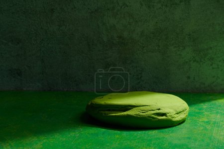 Foto de Pantalla de podio de piedra verde sobre fondo verde. Soporte decorativo texturizado para productos de belleza con spac de copia - Imagen libre de derechos