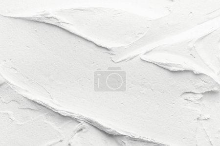 Photo for Decorative white putty background. Wall texture with filler paste applied with spatula, chaotic dashes and strokes over plaste - Royalty Free Image