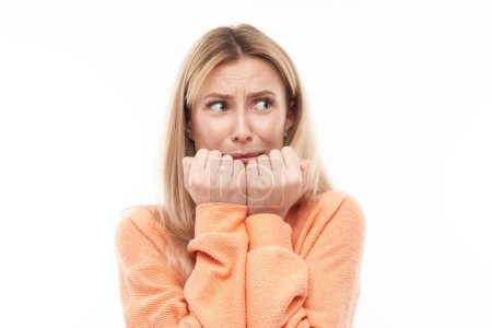 Photo for Portrait of scared young woman nervously biting nails isolated on white background. Stress, emotional burnout, self-doubt concep - Royalty Free Image