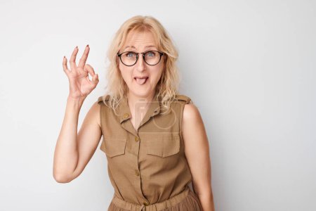 Foto de Retrato de mujer adulta mostrando signo OK con dedos aislados sobre fondo blanco. Carrera exitosa, concepto aceptado - Imagen libre de derechos