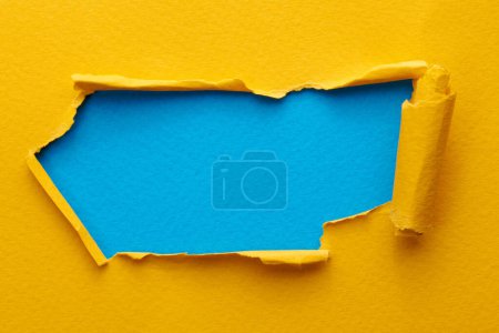 Photo for Frame of ripped paper with torn edges. Window for text with copy space yellow blue colors, shreds of notebook pages. Abstract backgroun - Royalty Free Image