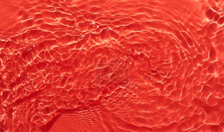 Foto de Agua superficie roja fondo abstracto. Ondas y ondas textura de la crema hidratante cosmética aqua con burbuja - Imagen libre de derechos