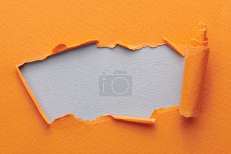 Photo for Frame of ripped paper with torn edges. Window for text with copy space orange gray colors, shreds of notebook pages. Abstract backgroun - Royalty Free Image