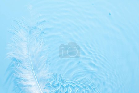 Téléchargez les photos : Surface bleu eau fond abstrait. Ondes et ondulations texture d'hydratant aqua cosmétique avec bulles et feathe blanche - en image libre de droit