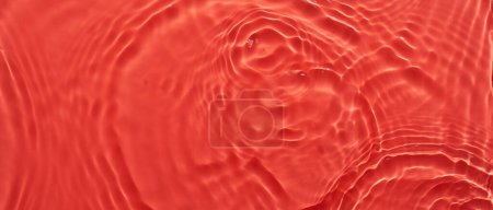 Téléchargez les photos : Eau rouge fond abstrait de surface. Ondes et ondulations texture d'hydratant aqua cosmétique avec bulle - en image libre de droit
