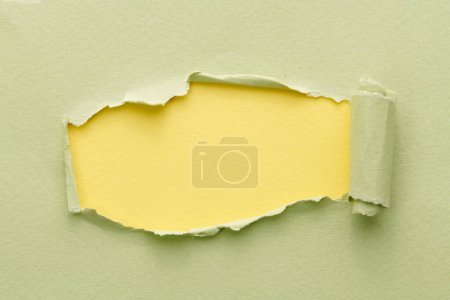 Foto de Marco de papel rasgado con bordes rotos. Ventana para texto con espacio de copia de color verde amarillo, fragmentos de páginas de cuaderno. Fondo abstracto - Imagen libre de derechos