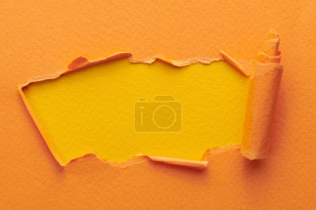 Photo for Frame of ripped paper with torn edges. Window for text with copy space yellow orange colors, shreds of notebook pages. Abstract backgroun - Royalty Free Image
