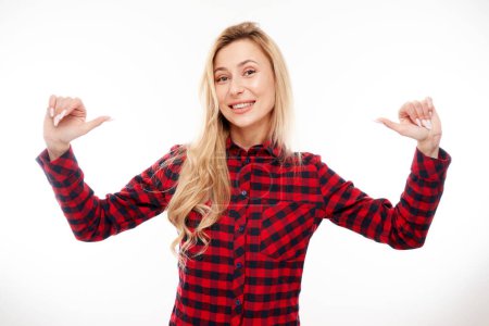 Photo for Portrait of young blonde woman smiling, looking confident, pointing oneself with fingers isolated on white background. Chooses herself, self-esteem concept - Royalty Free Image
