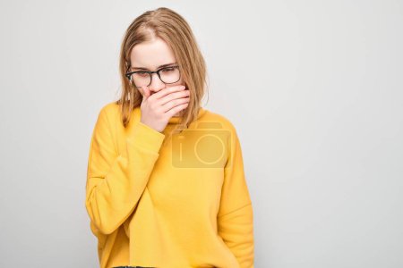 Photo for Portrait of young blond girl coughing, suffering from sore throat isolated on white studio background. Respiratory disease concept - Royalty Free Image