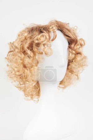 Foto de Peluca rubia de aspecto natural en la cabeza del maniquí blanco. Corte de pelo corto en el soporte de peluca de plástico aislado en fondo blanco - Imagen libre de derechos