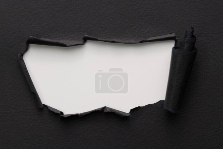 Photo for Frame of ripped paper with torn edges. Window for text with copy space black white colors, shreds of notebook pages. Abstract backgroun - Royalty Free Image