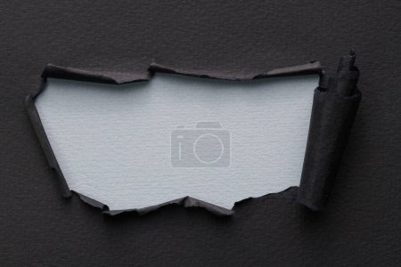 Photo for Frame of ripped paper with torn edges. Window for text with copy space gray black colors, shreds of notebook pages. Abstract backgroun - Royalty Free Image