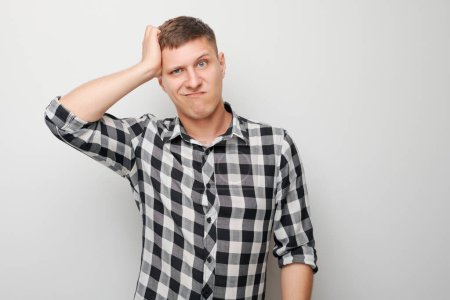 Portrait of clever man in shirt touching head thinks doubts chooses isolated on white studio background with copy space