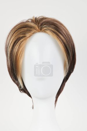 Natürliche dunkelbraune Perücke auf weißem Schaufensterpuppenkopf. Kurze braune Haare am Perückenhalter aus Kunststoff isoliert auf weißem Hintergrund, Vorderansicht 