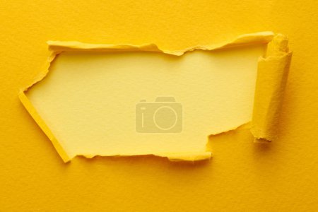 Photo for Frame of ripped paper with torn edges. Window for text with copy space yellow colors, shreds of notebook pages. Abstract backgroun - Royalty Free Image