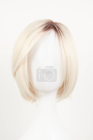 Téléchargez les photos : Perruque blonde blonde naturelle sur tête de mannequin blanche. Cheveux courts coupés sur le porte-perruque en plastique isolé sur fond blanc, front vie - en image libre de droit