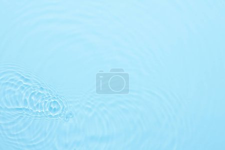 Téléchargez les photos : Surface bleu eau fond abstrait. Ondes et ondulations texture d'hydratant aqua cosmétique avec bulles - en image libre de droit