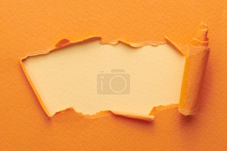 Photo for Frame of ripped paper with torn edges. Window for text with copy space orange beige colors, shreds of notebook pages. Abstract backgroun - Royalty Free Image