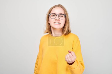 Photo for Portrait of angry schoolgirl yelling clenching fists isolated on white studio background. Devil face. Human emotions, facial expression concept - Royalty Free Image