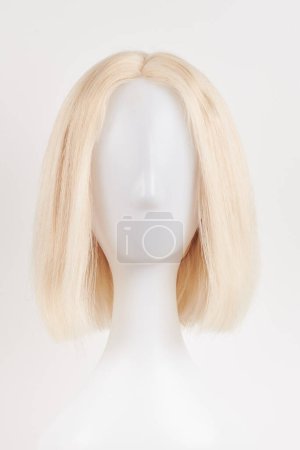 Téléchargez les photos : Perruque blonde blonde naturelle sur tête de mannequin blanche. Cheveux courts coupés sur le porte-perruque en plastique isolé sur fond blanc, front vie - en image libre de droit