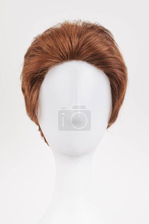 Téléchargez les photos : Perruque brune foncée à l'aspect naturel sur tête de mannequin blanche. Cheveux bruns courts sur le porte-perruque en plastique isolé sur fond blanc, vue de face - en image libre de droit