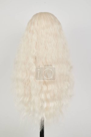 Photo for Natural looking blonde wig on white mannequin head. Long hair on the plastic wig holder isolated on white background, back vie - Royalty Free Image