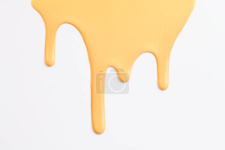 Foto de Mancha de pintura acrílica, pincelada caótica, mancha que fluye sobre fondo de papel blanco. Fondo creativo de color amarillo, ar fluido - Imagen libre de derechos