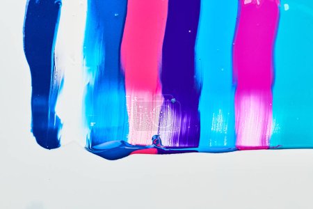 Foto de Mancha de pintura multicolor acrílica, pincelada caótica, mancha que fluye sobre el fondo de papel blanco. Fondo de color azul creativo, ar fluido - Imagen libre de derechos