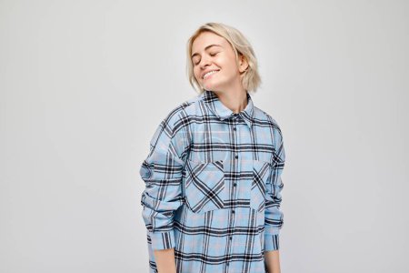 Photo for Portrait Caucasian young blond woman smiling joyfully isolated on white studio background. Happy girl in blue plaid shirt with glad face expressio - Royalty Free Image