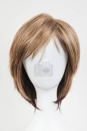 Photo for Natural looking dark brunet wig on white mannequin head. Short brown hair on the plastic wig holder isolated on white background, front view - Royalty Free Image