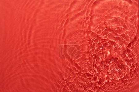 Téléchargez les photos : Eau rouge fond abstrait de surface. Ondes et ondulations texture d'hydratant aqua cosmétique avec bulle - en image libre de droit