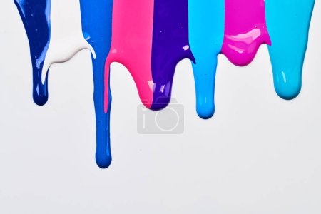 Foto de Mancha de pintura multicolor acrílica, pincelada caótica, mancha que fluye sobre el fondo de papel blanco. Fondo de color azul creativo, ar fluido - Imagen libre de derechos