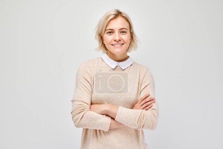 Photo for Portrait Caucasian young blond woman smiling joyfully isolated on white studio background. Happy girl in beige blouse with glad face expression - Royalty Free Image
