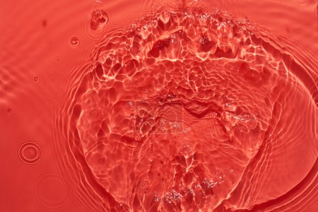 Foto de Agua superficie roja fondo abstracto. Ondas y ondas textura de la crema hidratante cosmética aqua con burbuja - Imagen libre de derechos