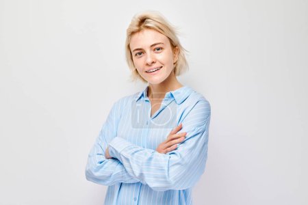 Photo for Portrait Caucasian young blond woman smiling joyfully isolated on white studio background. Happy girl in blue shirt with glad face expression - Royalty Free Image