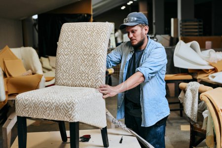 Téléchargez les photos : Travaux de menuiserie fait chaise en atelier de menuiserie. Homme faisant des meubles professionall - en image libre de droit