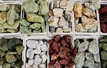 Foto de Conjunto de diferentes piedras de sauna en cajas. Rocas minerales naturales varios colores - Imagen libre de derechos