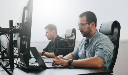 Foto de Retrato de dos programadores masculinos profesionales que trabajan en la computadora en diversas oficinas. Tecnologías de TI modernas, desarrollo de inteligencia artificial, programas, aplicaciones y concepto de videojuegos - Imagen libre de derechos