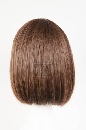 Photo for Natural looking dark brunet wig on white mannequin head. Middle length brown hair on the plastic wig holder isolated on white background, back vie - Royalty Free Image