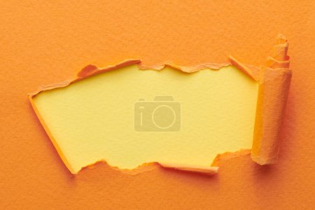Téléchargez les photos : Cadre en papier déchiré avec bords déchirés. Fenêtre pour texte avec espace de copie couleurs orange-jaune, lambeaux de pages de cahier. Backgroun abstrait - en image libre de droit