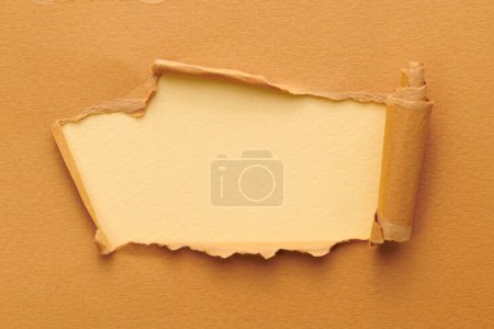 Photo for Frame of ripped paper with torn edges. Window for text with copy space beige brown colors, shreds of notebook pages. Abstract backgroun - Royalty Free Image