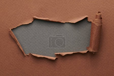 Photo for Frame of ripped paper with torn edges. Window for text with copy space grey brown colors, shreds of notebook pages. Abstract backgroun - Royalty Free Image