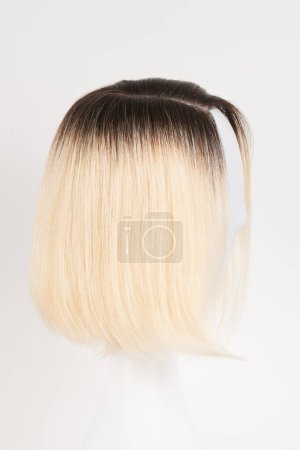 Téléchargez les photos : Perruque blonde blonde naturelle sur tête de mannequin blanche. Coupe de cheveux courts sur le support de perruque en plastique isolé sur fond blanc, vie latérale - en image libre de droit