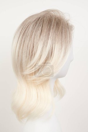 Téléchargez les photos : Perruque blonde blonde naturelle sur tête de mannequin blanche. Cheveux mi-longs coupés sur le porte-perruque en plastique isolé sur fond blanc, vie latérale - en image libre de droit